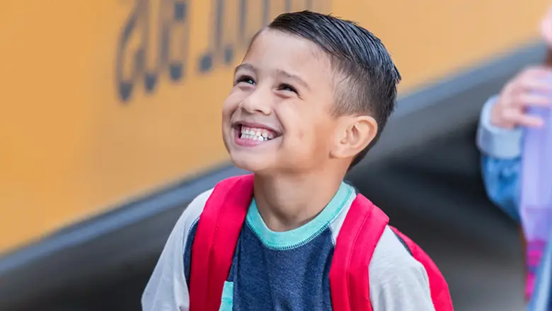 smiling kid ready to board a school bus