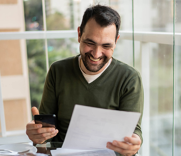 Man looking at his finances over breakfast.