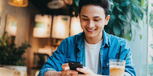 Young man looking at his smartphone in a coffee shop.
