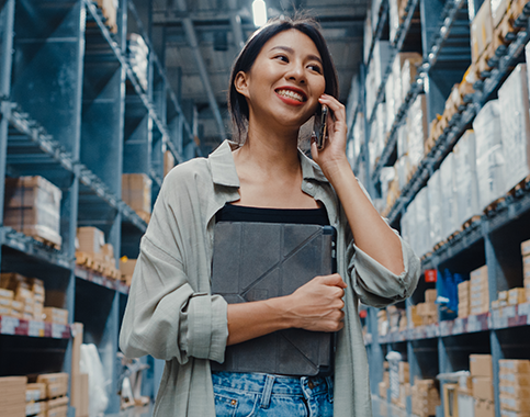 woman on the phone while walking through a warehouse