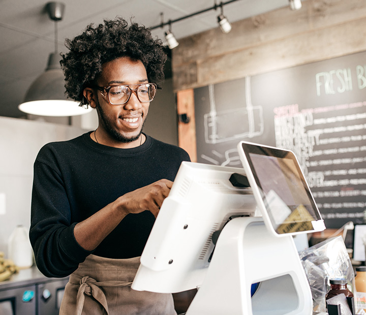 Man using a register at a coffee shop