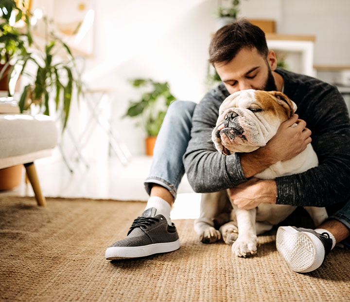 man kissing dog on the head