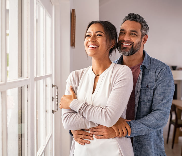 husband and wife looking out a window