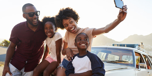 family taking a selfie on their car