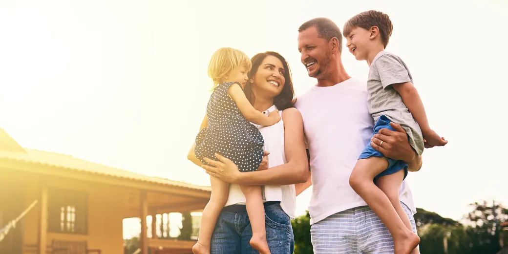 Family of four walking outdoors in sunshine