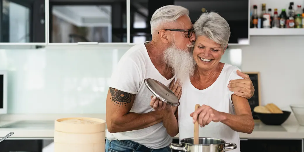 Older couple kissing in kitchen