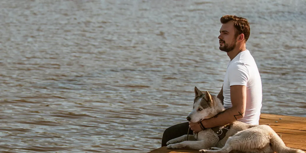Man with dog at a dock
