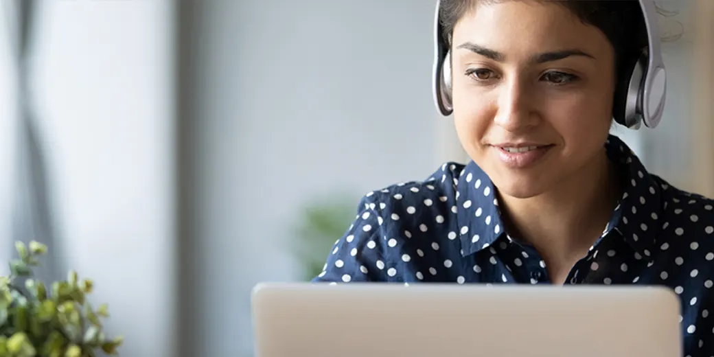 Young woman with headphones at laptop
