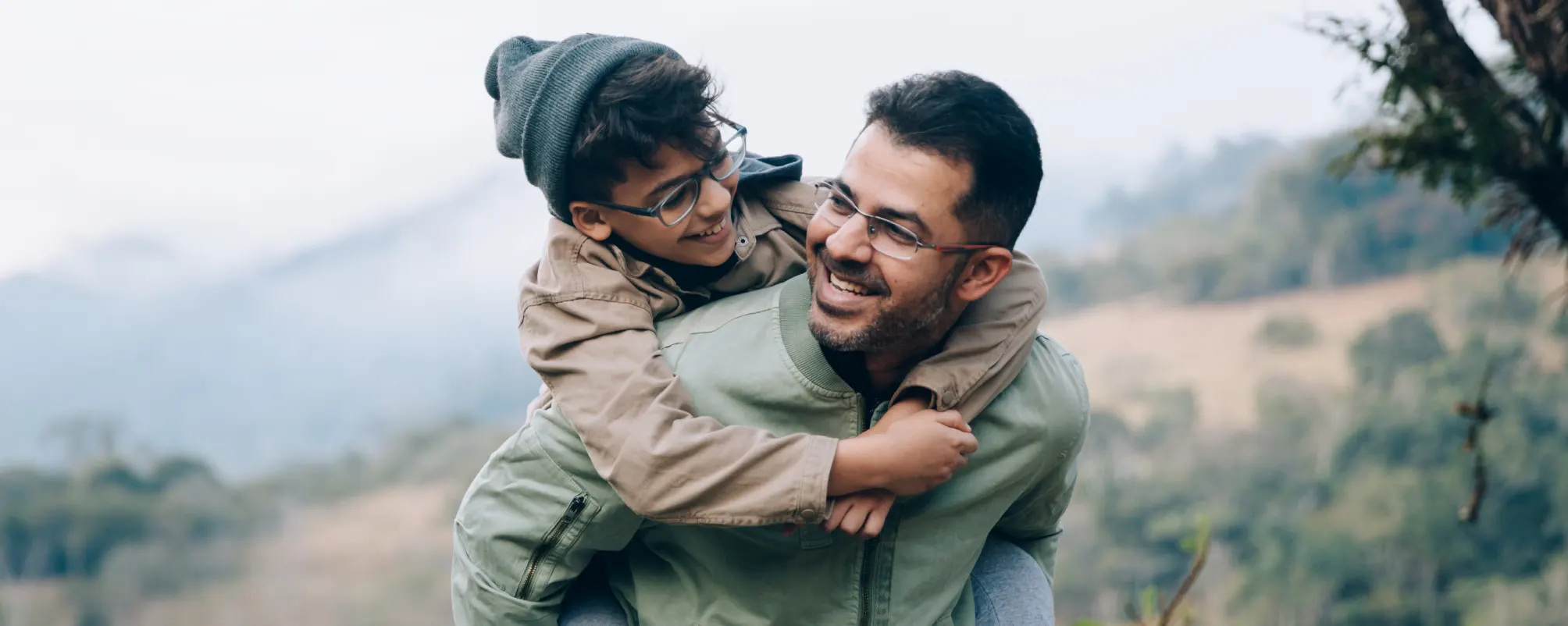 Father carrying son on back